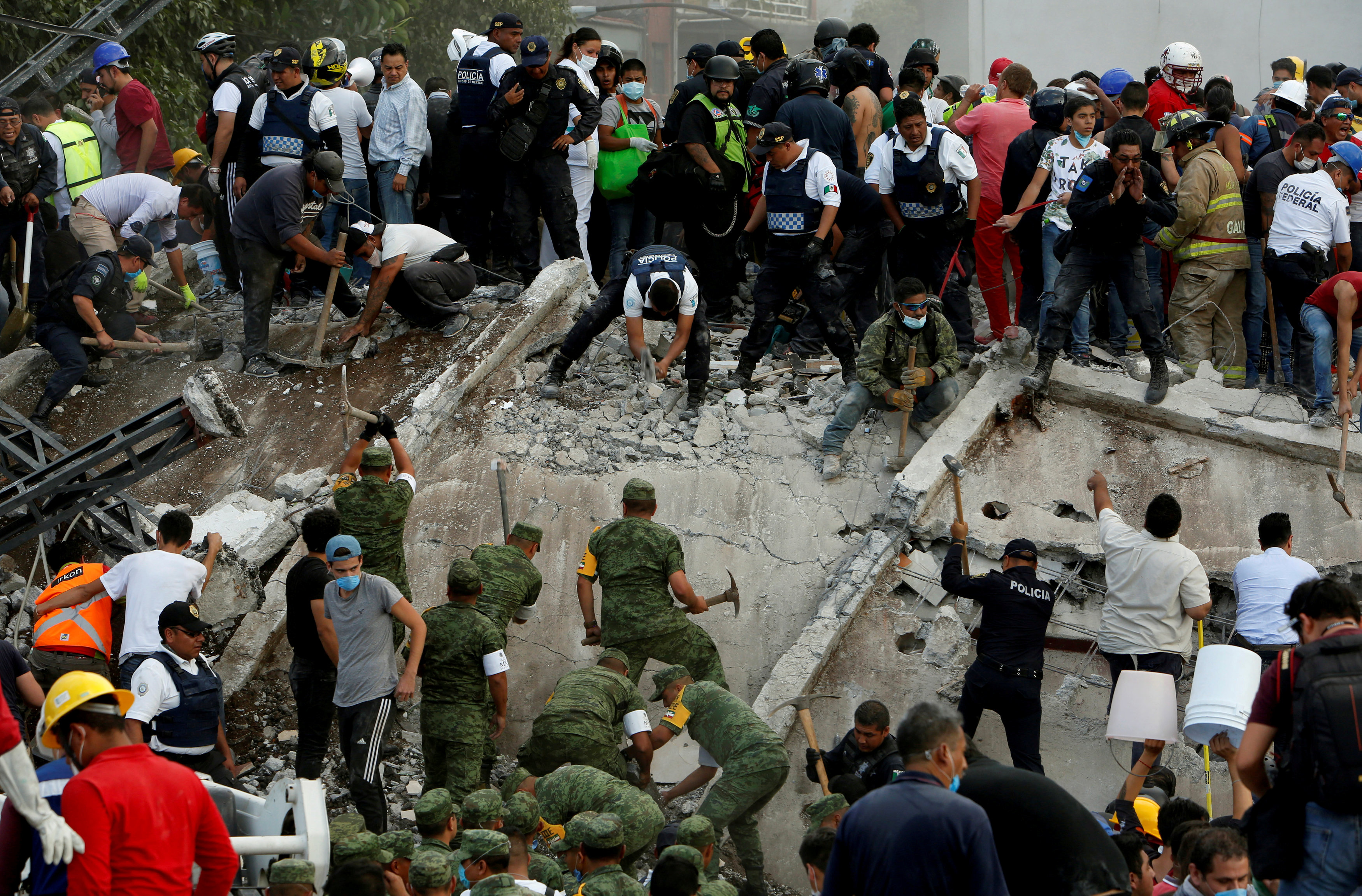 Soldiers, rescuers and people work at a collapsed building after an earthquake in Mexico City, Mexico