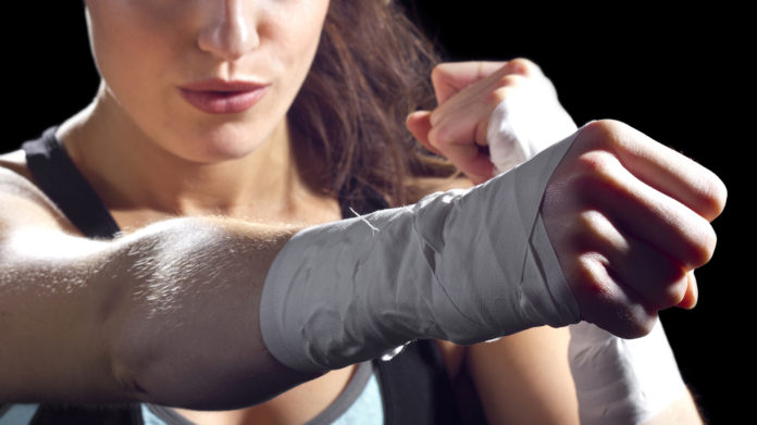 A female MMA fighter giving a strong punch